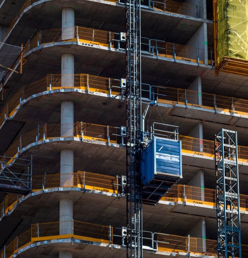 High-rise building construction site with tower crane and multi-level scaffolding