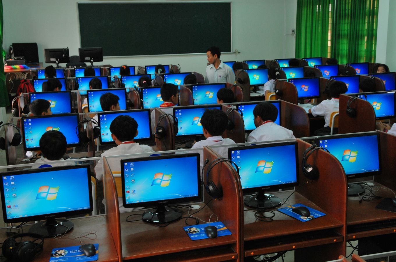Students learning in a computer laboratory with multiple monitors