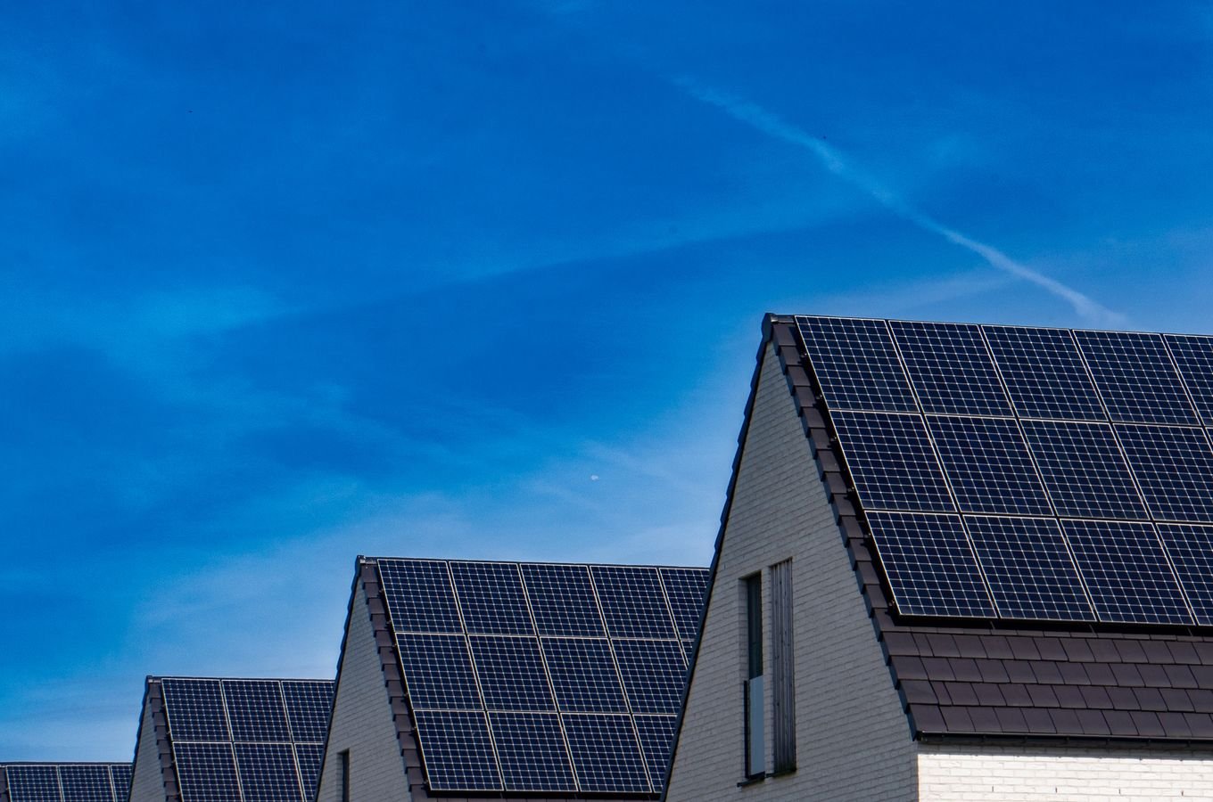 Rooftop solar panels installed on buildings under a bright sky