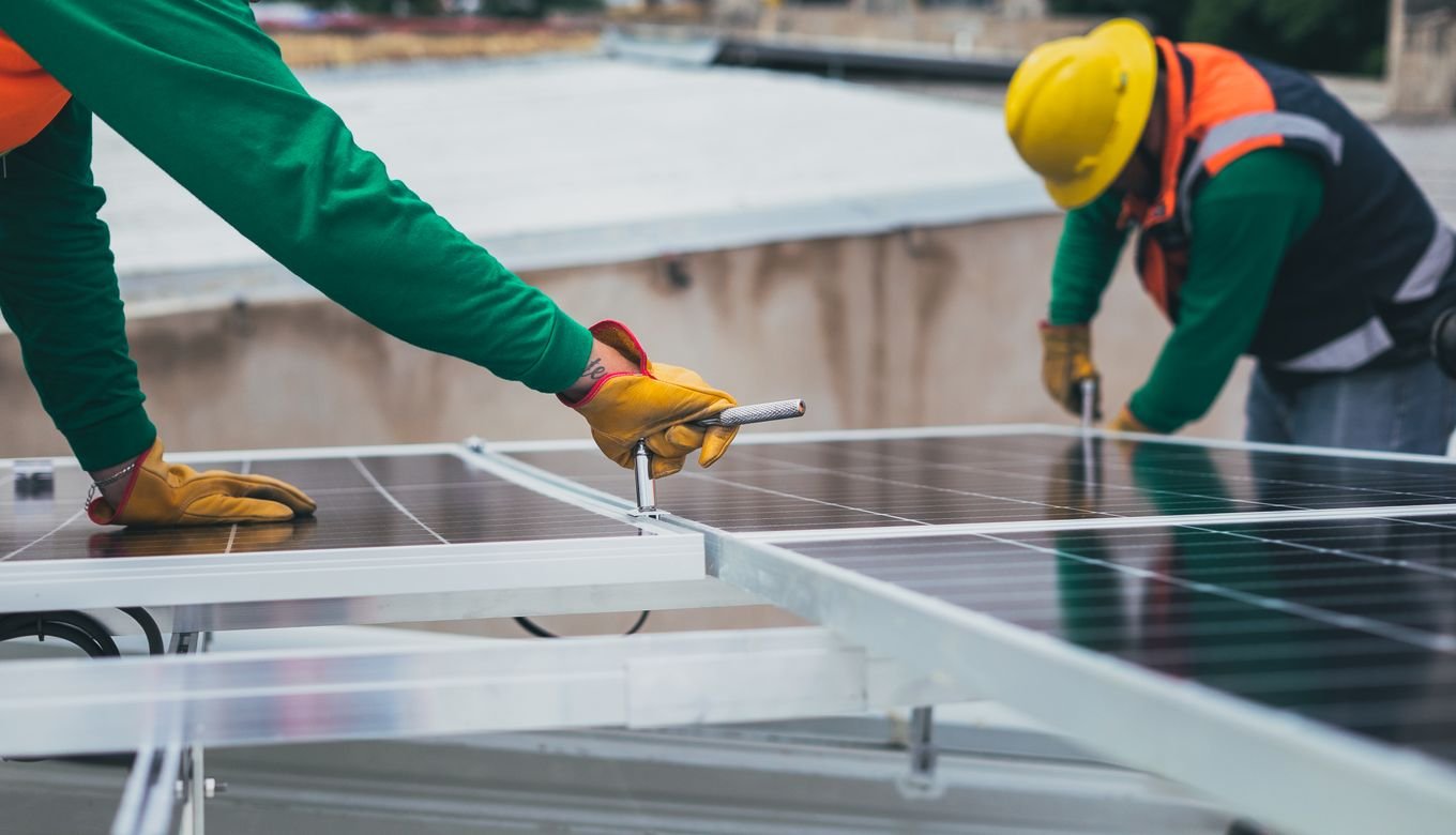 Workers securing solar panels on a rooftop