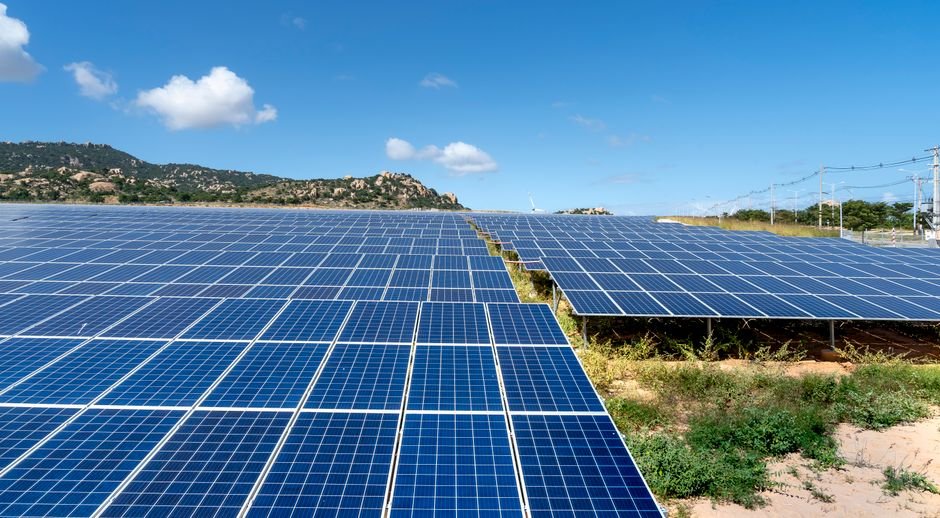 Field of solar panels under a clear blue sky